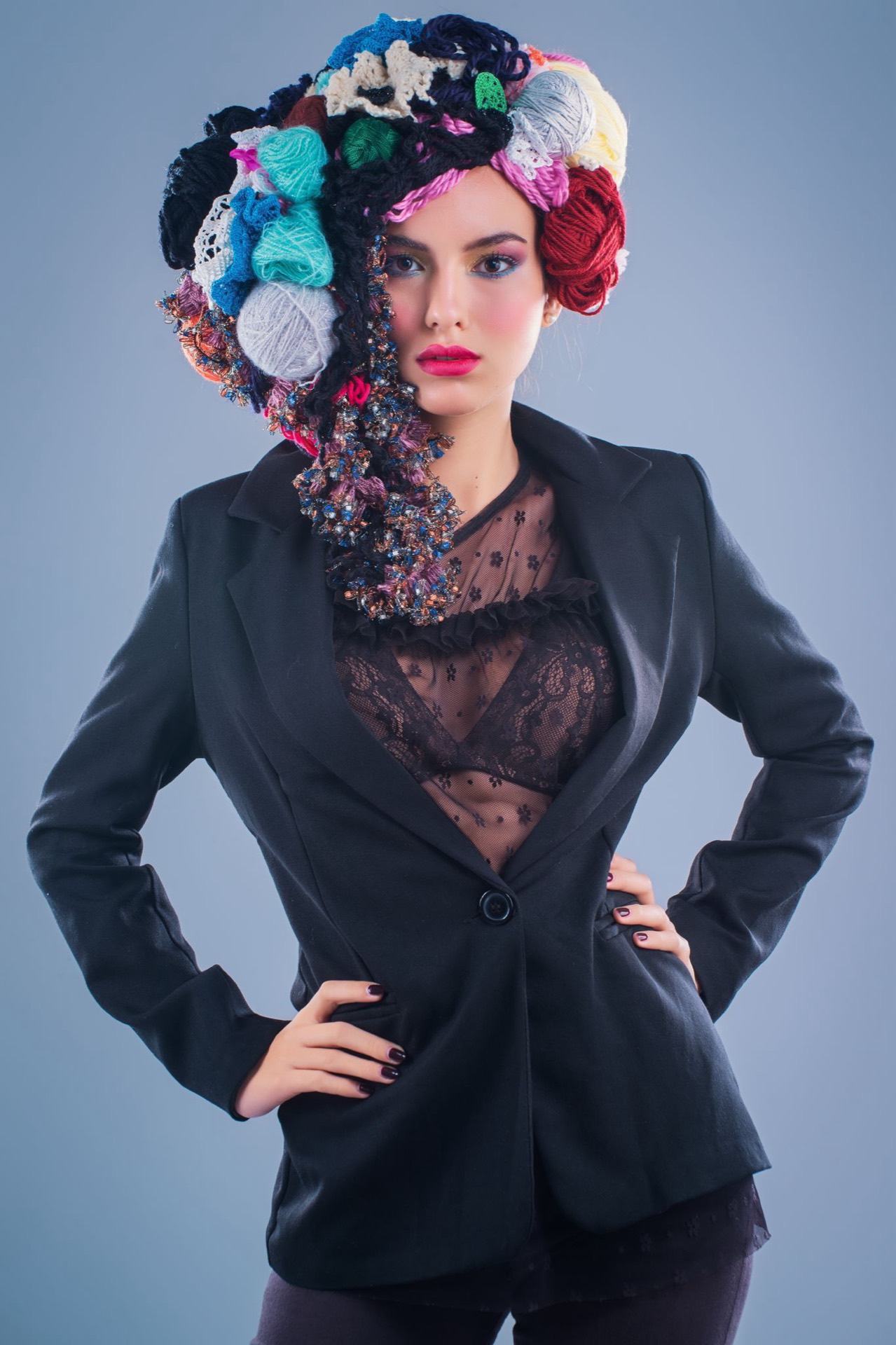 Ritratto creativo di donna con acconciatura realizzata con filati colorati